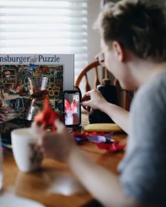 Man making a video on his phone at his kitchen table