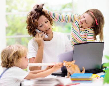 Mom working from home while children play and make noise around her