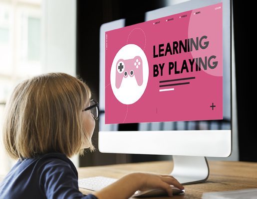 Young student playing educational game "Learning by Playing" at workstation