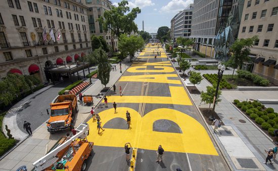 WASHINGTON, DC - JUNE 05: People walk down 16th street after volunteers, with permission from the city, painted "Black Lives Matter" on the street near the White House on June 05, 2020 in Washington, DC. After seven days of protests in DC over the death of George Floyd, DC Mayor Muriel Bowser has renamed that section of 16th street "Black Lives Matter Plaza". (Photo by Tasos Katopodis/Getty Images)