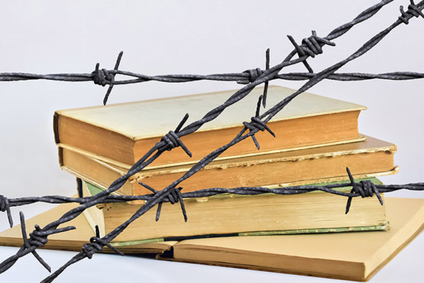 Books surrounded by barbed wire