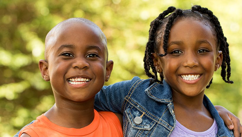 Boy and girl, arm in arm and smiling