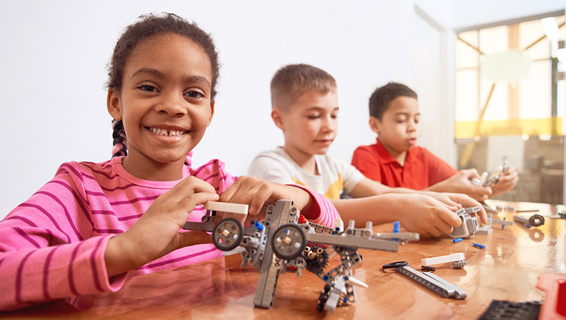 Students building mini-airplanes as part of a project-based learning exercise, important for teaching social-emotional learning skills