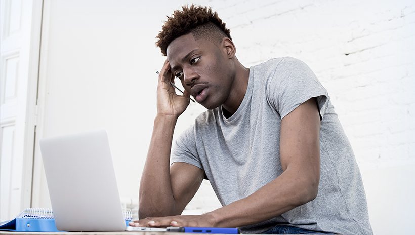 Stressed-out male high school student at laptop