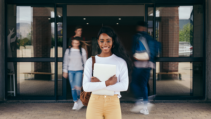 Cheerful college student in front of a building