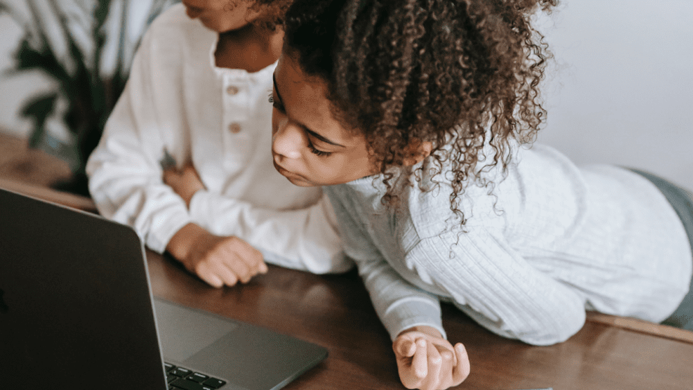 Two young students engaged in virtual learning